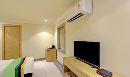 加尔各答Treebo Trend ASL Prime的一间卧室配有一张床和一台平面电视