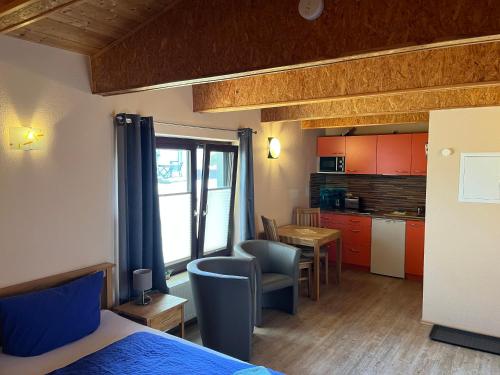洛默Ferienanlage Bullerbü的一间卧室配有一张床,厨房配有桌子