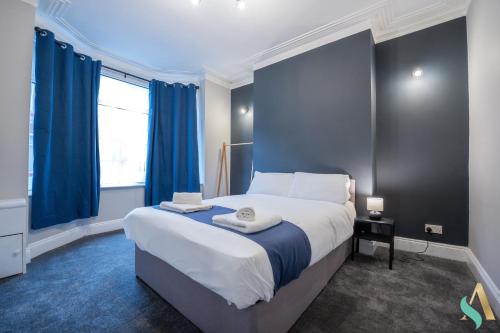 蒂斯河畔斯托克顿Trent House TSAC的一间卧室配有一张带蓝色窗帘的大床