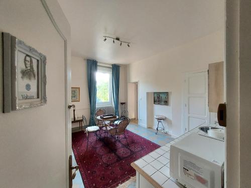萨尔拉拉卡内达Manoir Petit Meysset的厨房以及带桌椅的起居室。