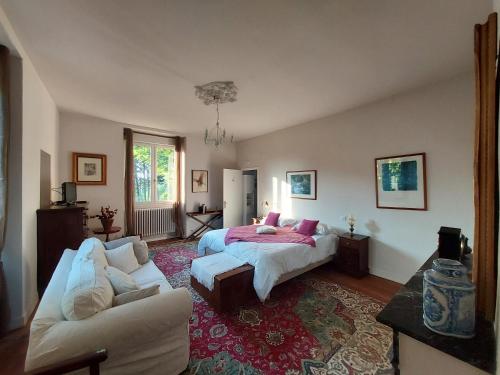 萨尔拉拉卡内达Manoir Petit Meysset的一间卧室配有一张床和一张沙发