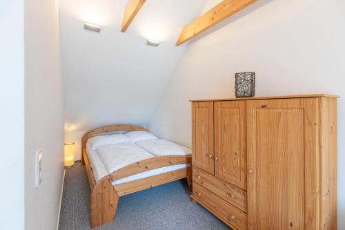 布雷茨特Haus zu den Halligen的一间卧室配有木床和木柜