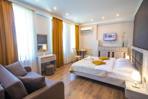 库塔伊西Hotel Terrace Kutaisi的一间卧室配有一张床,客厅配有沙发