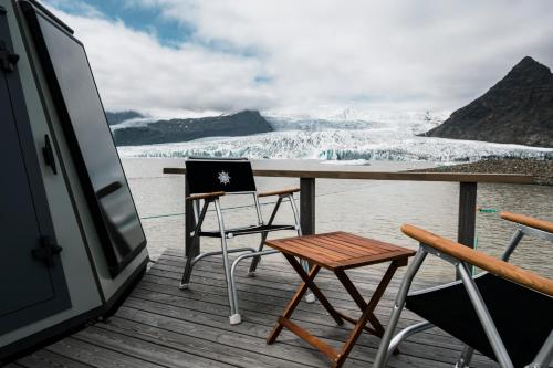 霍夫Fjallsarlon - Overnight adventure的享有冰川景致的甲板上的桌椅