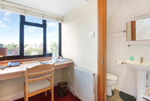 伦敦The Brent Hotel - London - Wembley的一间带水槽和卫生间的浴室以及窗户。