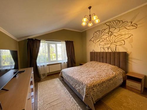 休钦斯克Гостевой дом的卧室配有一张挂着花壁画的床。