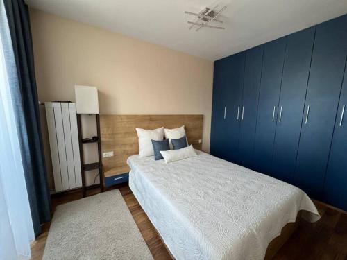 索非亚Cozy and bright apartment的一间卧室配有一张带蓝色橱柜的大床