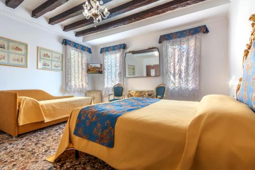 威尼斯卡萨波卡希尼酒店的一间卧室配有两张床、一张沙发和镜子