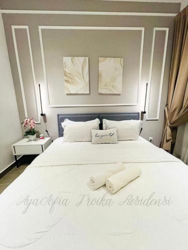 哥打巴鲁AYASOFIA TROIKA CITY VIEW ( Wifi, Netflix, 4-6 pax)的卧室配有一张白色大床和两条毛巾