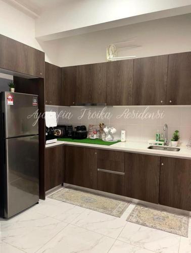 哥打巴鲁AYASOFIA TROIKA CITY VIEW ( Wifi, Netflix, 4-6 pax)的厨房配有木制橱柜和不锈钢冰箱。