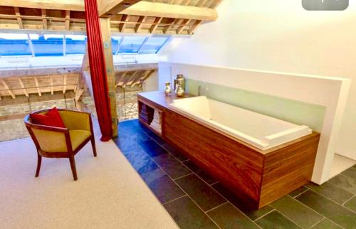 普里茅斯Royal William Yard Apartments - Large and Luxurious with Free Parking的一间带浴缸的浴室和一把椅子
