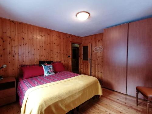 坎波多尔奇诺Appartamento sul Liro的卧室配有一张床铺,位于带木墙的房间内