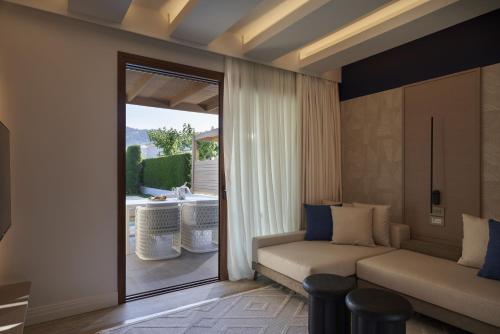 科林比亚Atlantica Holiday Village Rhodes的带沙发和滑动玻璃门的客厅