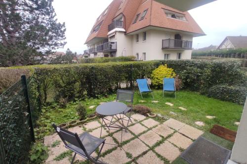 卡布尔37m with terrace and garden near the sea的房子前面有三把椅子和一张桌子