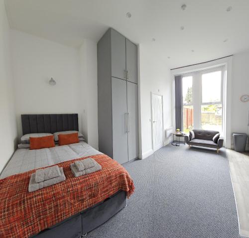 哈德斯菲尔德Edgerton Studios的一间卧室配有一张带橙色毯子的大床