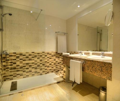 托莱多比阿特丽斯托莱多礼堂水疗酒店的带浴缸、水槽和镜子的浴室