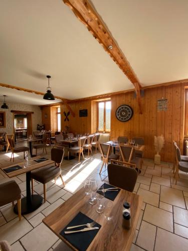 Chaux-des-CrotenayHôtel Restaurant des Lacs的餐厅拥有木墙和桌椅