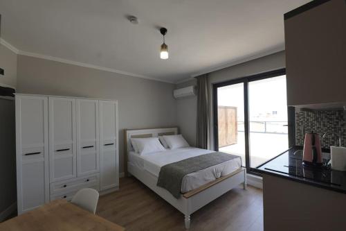 安塔利亚Royal Homes 506的一间卧室配有一张床、一张桌子和一个窗户。