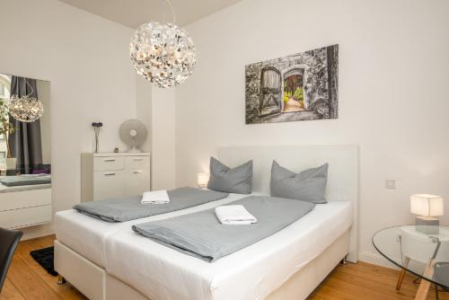 莱比锡Apartments an der Arena Leipzig的白色的卧室配有白色的床和一张桌子