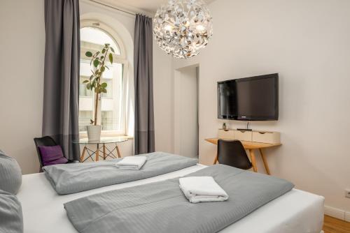 莱比锡Apartments an der Arena Leipzig的一间卧室配有两张床和一台平面电视