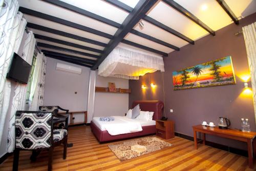 达累斯萨拉姆客及及海滩度假酒店的卧室配有一张床和一张桌子及椅子