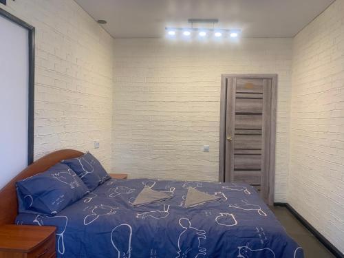罗夫诺Апартаменти на вул. Біла,5а的一间卧室配有一张带蓝色棉被的床