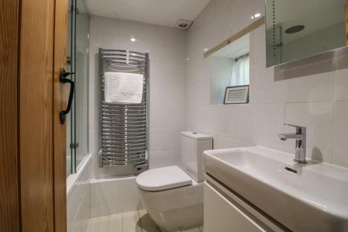 圣阿格尼丝2 Rose Cottages的白色的浴室设有卫生间和水槽。