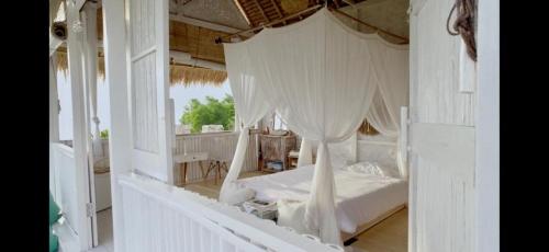 珀尼达岛Ocean Glamping Penida的一间卧室配有一张带天蓬的白色床