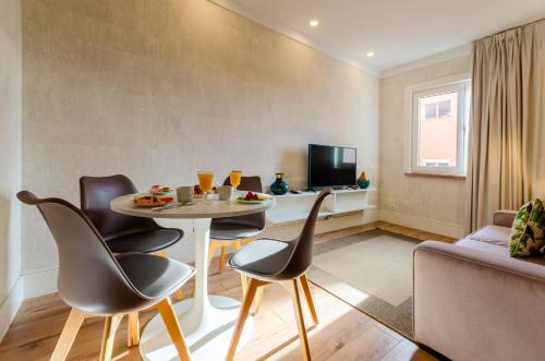 里斯本LX51 Studios & Suites by APT IIN的客厅配有桌椅和电视。