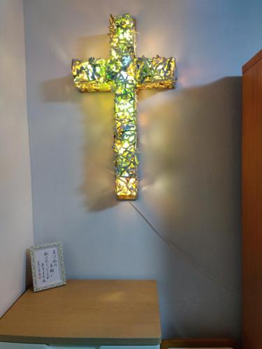 那霸Miyagi Apartment Tomari的挂在桌子旁边的墙上的十字架