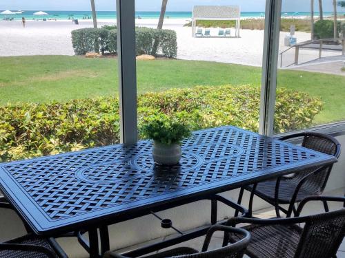 西耶斯塔岛Island House Beach Resort 2S的凉桌,门廊上挂着盆子植物