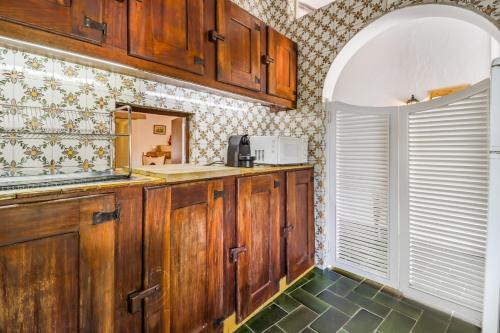 奥埃拉斯Casa do Mar - Golf Jamor的厨房配有木制橱柜和窗户。