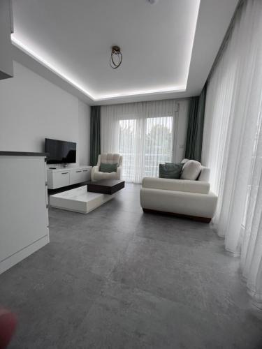 阿拉恰特Luna Alacati的客厅配有2张白色沙发和1台电视