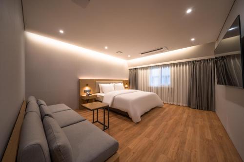 首尔Comfort inn Yeouido的酒店客房,配有床和沙发