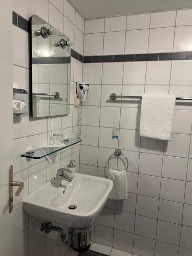 巴本豪森黑狮酒店的白色的浴室设有水槽和镜子