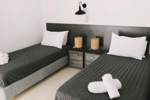 克拉法吉亚Grey House的一间卧室配有两张带白色十字架的床。
