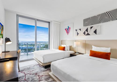 好莱坞HYDE BEACH HOUSE #2408 THREE-BEDROOM, WATERFRONT, OCEAN AND INTERCOSTAL VIEW, ROOFTOP POOL, 5 MiN WALK TO BEACH的酒店客房设有两张床和大窗户。