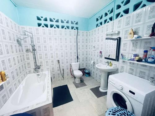 SadaLa maison bleue的带浴缸、水槽和洗衣机的浴室
