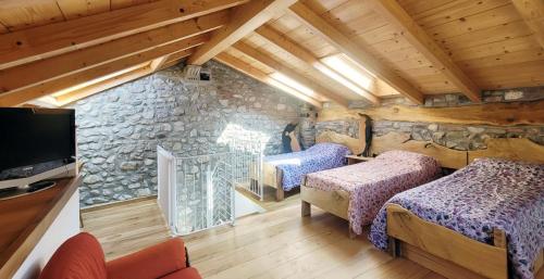 BallabioBALLABIO LAKE - Rustic Chic Retreat的一间卧室设有两张床和石墙