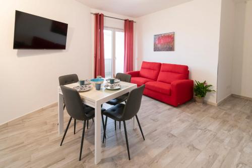 马里诺Casa Larry的客厅配有桌子和红色沙发