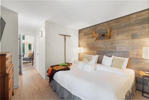蒙特朗布朗Le Champetre Tremblant 2bdrs Condo W Fireplace的一间卧室配有一张大床和木制床头板