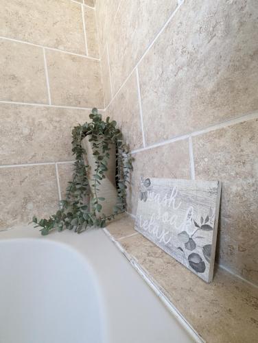 Kent1 bedroom flat in Gravesend的带浴缸的浴室,内配植物