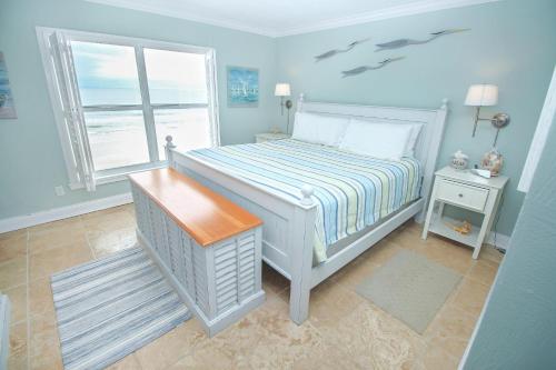新士麦那海滩Sea Coast Gardens II 401的蓝色的卧室设有床和窗户