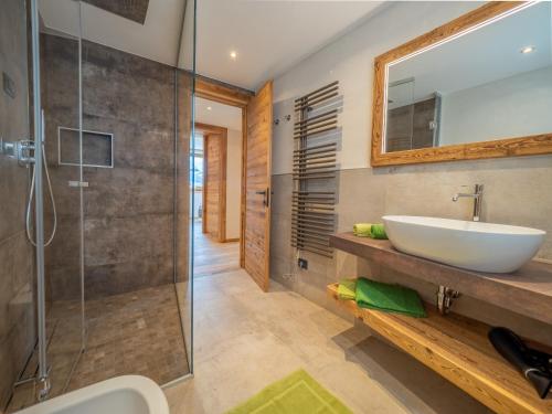 利维尼奥Deschana Lodge的一间带水槽和玻璃淋浴的浴室
