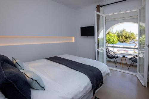 提诺斯SEAMENTO suites的一间卧室设有一张床和一个滑动玻璃门