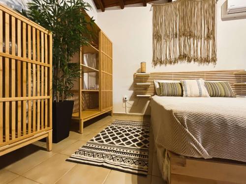 梅加利阿莫斯Spitaki Guest House的一间卧室配有一张床和盆栽植物