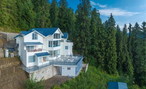 纳尔卡恩达Echor Backwoods Villa Narkanda的享有白色房子空中美景,设有蓝色屋顶