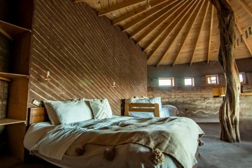 圣佩德罗·德·阿塔卡马Vernacular Lodge的木天花板的客房内的一张床位