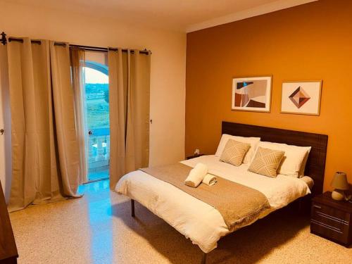 SiġġiewiLovely 3 bedroom in Siggiewi的一间卧室设有一张大床和一个大窗户