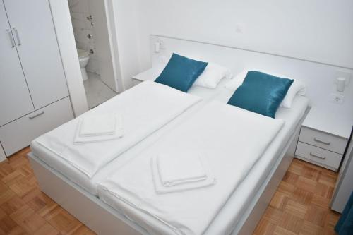 普纳特Villa Rosa Rooms的客房内的白色床和蓝色枕头